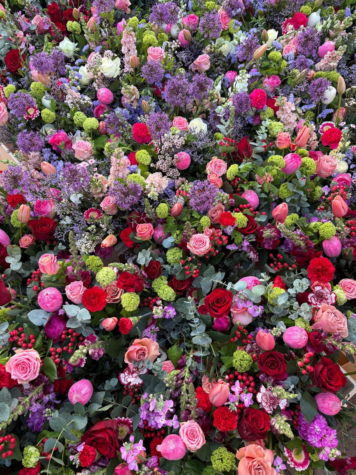 Een vogelperspectief afbeelding van bloemen met een kleurentoon van paars en rood
